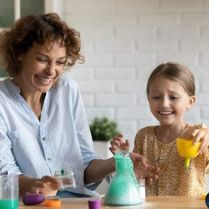 ScienceLab Kursleiterin experimentiert mit Kindern – Forschen macht Spaß und verbindet.